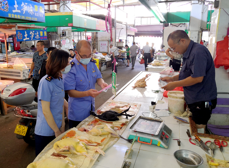 市场监管部门工作人员检查农贸市场白条禽经营摊位进货票据情况（区市场监管局供图）.jpg