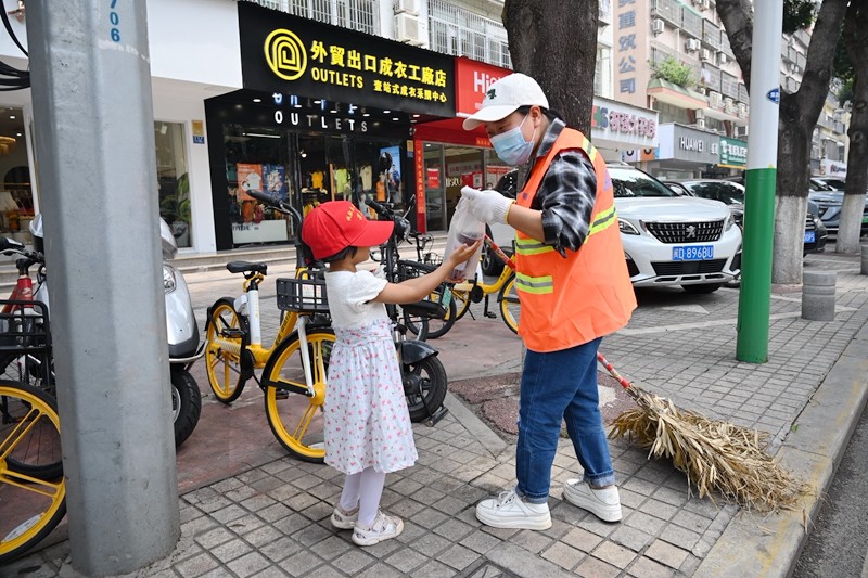 小志愿者给环卫工人送上柠檬茶(拍摄 冯立东).JPG