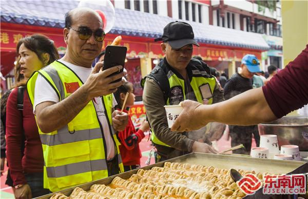 图为摩友们纷纷进入美食节品尝美食。董观生摄.jpg