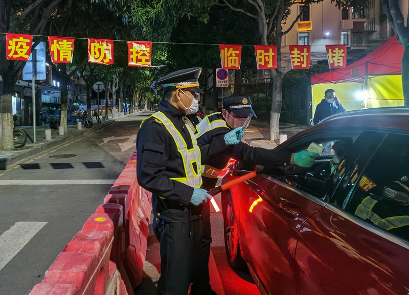 守住疫情防控的第一道防线。图为，集美街道辖区各路口实行24小时设点检测，夜间工作人员对驾驶员测量体温（林志杰摄影）-181737.jpg