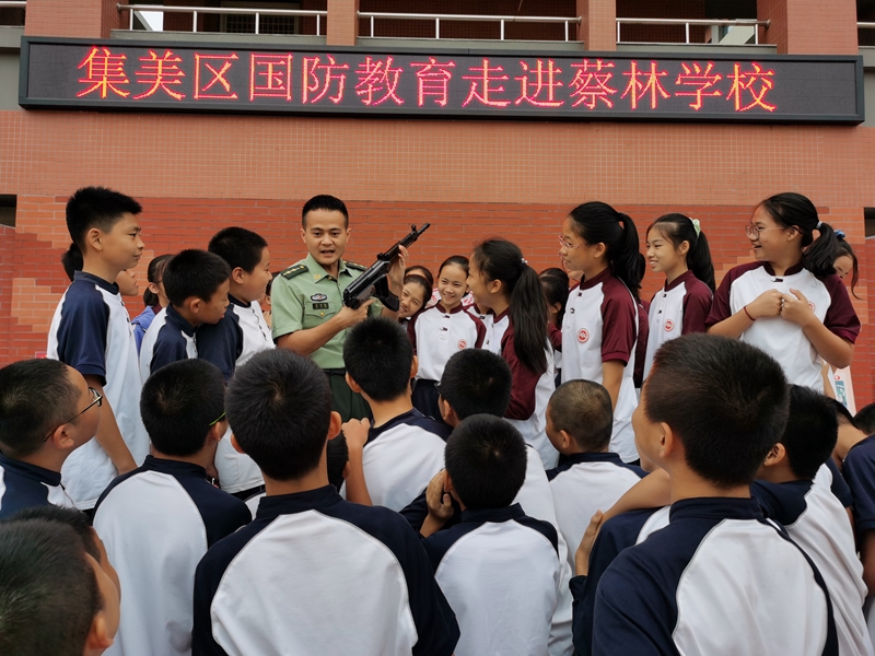 蔡林学校学生兴致高昂的听取轻武器操作使用介绍（区武装部供图）.jpg